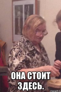  Она стоит здесь.