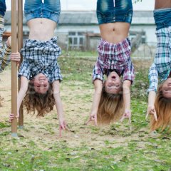 Four-young-girls-hanging-upside-down-in-park